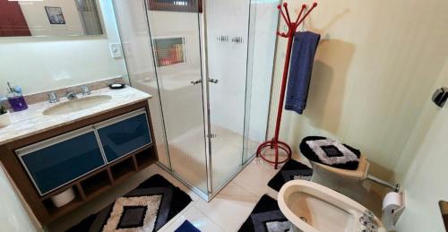 uma casa de banho com um chuveiro, um WC e um lavatório. em Apartamento Duplex Alto do Capivari em Campos do Jordão