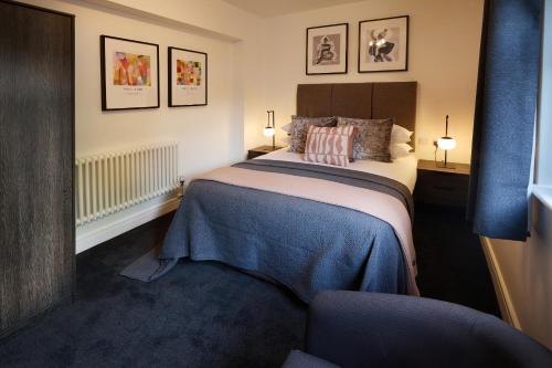 - une chambre avec un lit et une couverture bleue dans l'établissement The Woden Boutique Hotel Walsall M6 J9, à Walsall