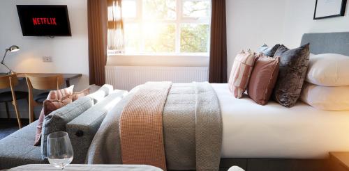sypialnia z łóżkiem, kanapą i oknem w obiekcie The Woden Boutique Hotel Walsall M6 J9 w mieście Walsall