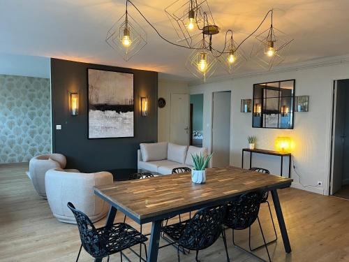 un salon avec une table et des chaises en bois dans l'établissement LE PHARE, grand appartement face mer, au Tréport
