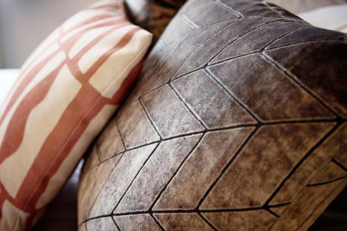 a close up of a brown leather cushion with red and white stripes at The Woden Boutique Hotel Walsall M6 J9 in Walsall