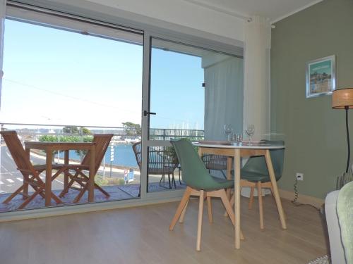 un salon avec une table et des chaises et un balcon dans l'établissement LE HAVRE DE BABOU, à Perros-Guirec