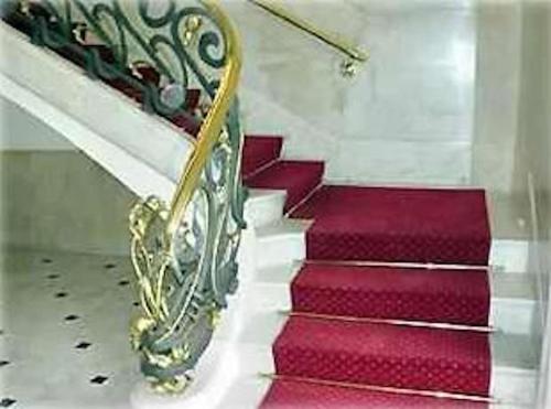 a set of red and white stairs with a gold railing at Passeig de Gracia Studio Loft in Barcelona