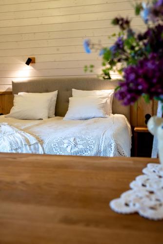 a bed with white sheets and pillows on top of a table at Haanjamehe Taluhotell in Haanja