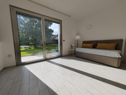a bedroom with a bed and a large window at Villa Persea in Santa Venerina
