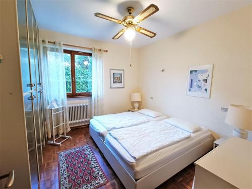 a bedroom with a bed and a ceiling fan at Home in Maccagno con Pino e Veddasca with garden in Maccagno Inferiore