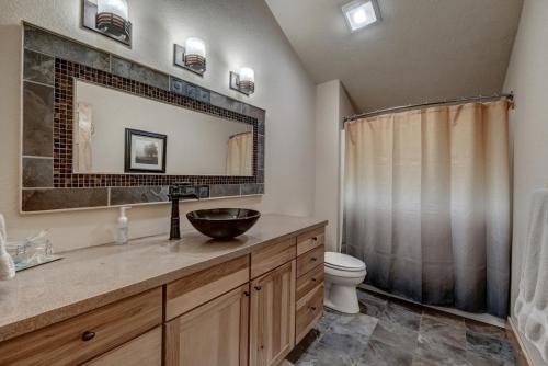 ein Badezimmer mit einem Waschbecken, einem WC und einem Spiegel in der Unterkunft Avalanche Chalet At Terry Peak Ski Resort in Lead