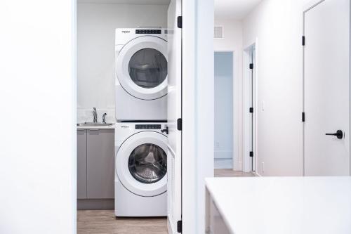 a white laundry room with a washer and dryer at Serenity Now by Revelstoke Vacations in Revelstoke