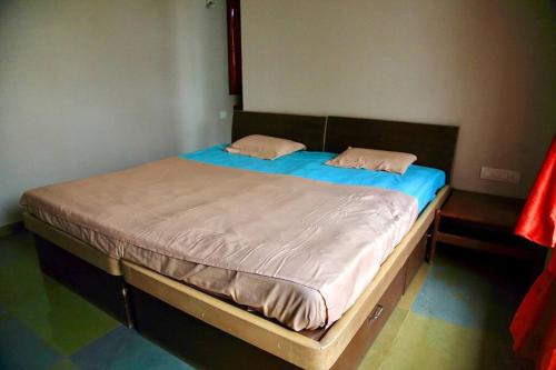 ein Bett mit zwei Kissen auf einem Zimmer in der Unterkunft RaghavaVijayam in Kolhapur