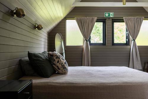1 dormitorio con 1 cama y 2 ventanas en Akureyri Retreat, en Akureyri