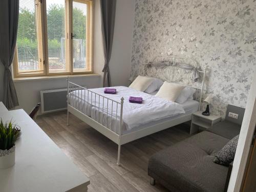- une petite chambre avec un lit et un canapé dans l'établissement Vila 1921, à Jevišovice