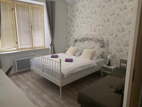 a small bedroom with a bed and a couch at Vila 1921 in Jevišovice