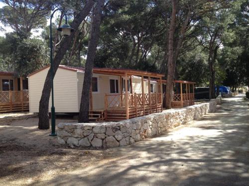 a cabin with a stone wall in front of a house at Comfortable chalet with two bathrooms at 31 km from Zadar in Biograd na Moru