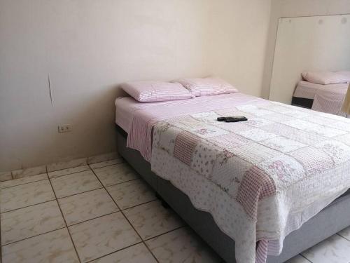 ein Schlafzimmer mit einem Bett mit einer rosa und weißen Decke in der Unterkunft Hermoso dpto en la victoria con todos los servicio in La Victoria