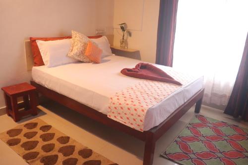 a bedroom with a bed with white sheets and a window at Coorg Northbreeze Estate stay in Madikeri