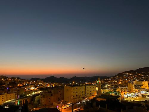 een heteluchtballon die 's nachts over een stad vliegt bij Petra Sky Hotel in Wadi Musa