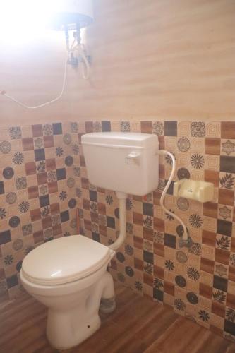 a bathroom with a toilet with a light above it at Coorg Northbreeze Estate stay in Madikeri