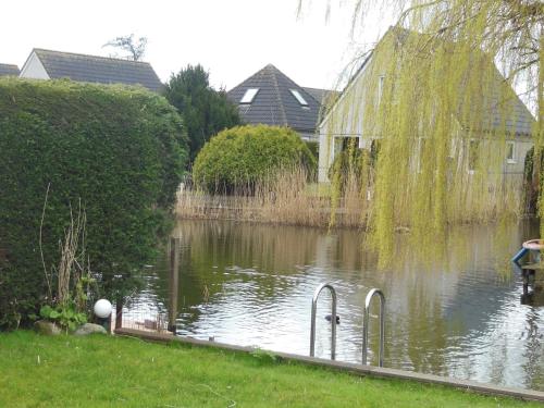 a pond with a duck in the middle of it at Detached bungalow with dishwasher at the water in Medemblik
