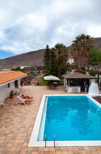 une grande piscine bleue à côté d'une maison dans l'établissement Ventoso , Modern Rustic Stay, à Santiago del Teide