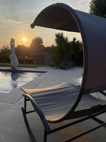 a chair sitting next to a pool with the sunset at Nakupenda Relais 