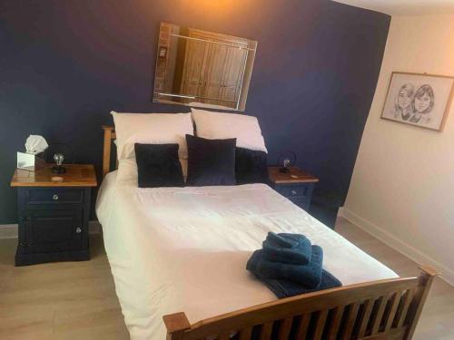 une chambre avec un grand lit avec deux tables de nuit dans l'établissement Quaint 1 bedroom cottage in Pudsey, Leeds, à Pudsey