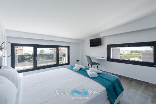 - une chambre avec un grand lit et des fenêtres dans l'établissement Grand Wave Luxury Suites, à Flogita
