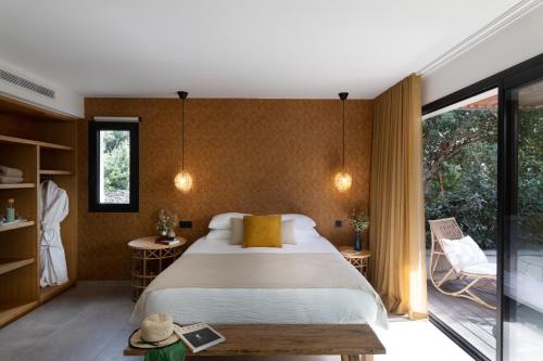 - une chambre avec un grand lit et un balcon dans l'établissement Aria Cigala, à Bonifacio
