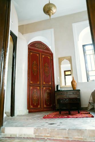 a large wooden door in a room with a dresser at Riad Dar Zaouia in Marrakech