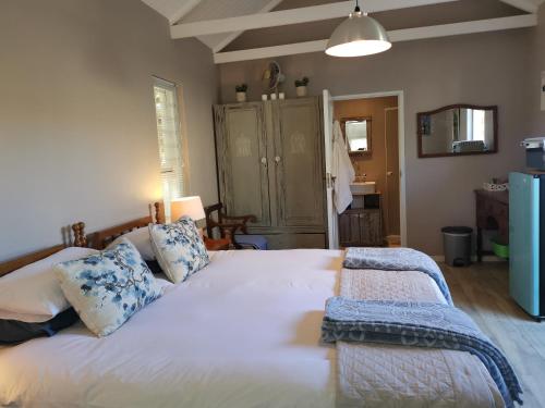una camera da letto con un grande letto bianco con cuscini blu di 30 Oak Street a Greyton