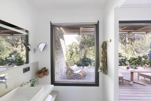 a bathroom with a window with a chair in it at Aria Cigala in Bonifacio