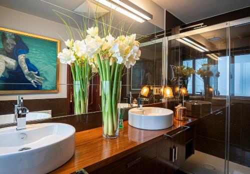 a bathroom with two sinks and a vase of flowers on a counter at Lujoso apartamento Centro a 3 minutos de la playa in A Coruña