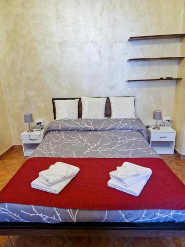 a bed with two white towels on a red blanket at Bardonecchia Central Studio Apartment - Frejus Palace in Bardonecchia