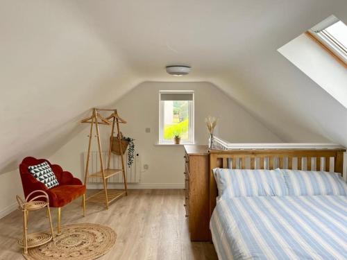 una camera da letto con un letto e una sedia in mansarda di Muckish Maison a Dunfanaghy