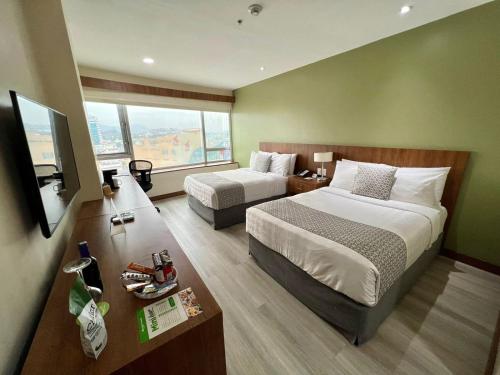 グアヤキルにあるWyndham Garden Guayaquilのベッド2台とテレビが備わるホテルルームです。