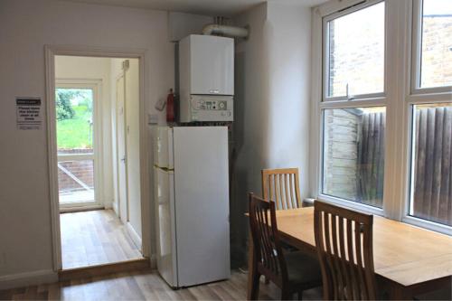 uma cozinha com um frigorífico, uma mesa e uma janela em Urban Retreat em Londres