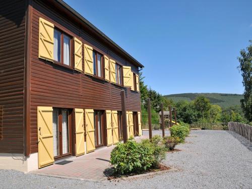 a building with brown and yellow windows on it at Holiday home with a panoramic view of the Ourthe on a quietly located property in La Roche-en-Ardenne