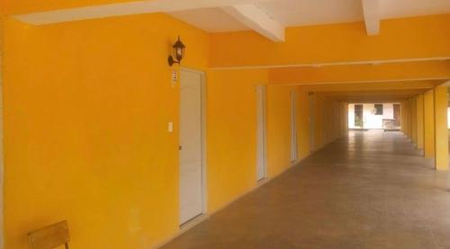 um quarto vazio com paredes cor de laranja e um corredor em Hotel Regina “El Llano” em Cosalá