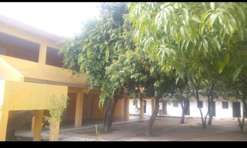 un edificio amarillo con árboles delante de él en Hotel Regina “El Llano”, en Cosalá