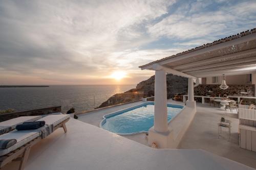 a villa with a swimming pool and a view of the ocean at Ode Villa in Oia