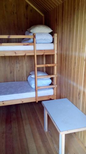 a room with two bunk beds and a table at Pūķarags - Kempings in Pape
