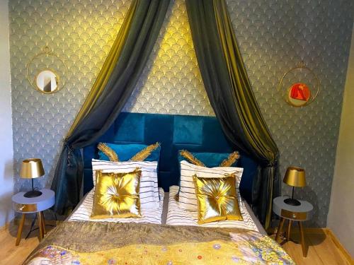 a bedroom with a blue canopy bed with pillows at Gold room in Krakow