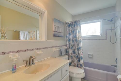 a bathroom with a sink and a toilet and a mirror at 4 Mi to Dog Beach Largo Home with Pool and Hot Tub! in Largo