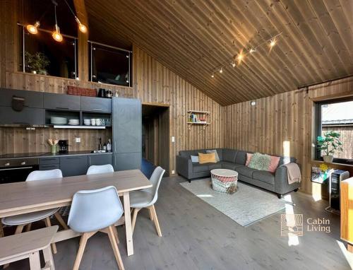 ein Wohnzimmer mit einem Tisch und einem Sofa in der Unterkunft Modern ap next to the ski stadium, alpine slope in Sjusjøen