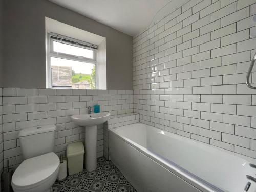 a bathroom with a toilet and a sink and a tub at Bluebell Cottage in the Yorkshire Dales in Stainforth