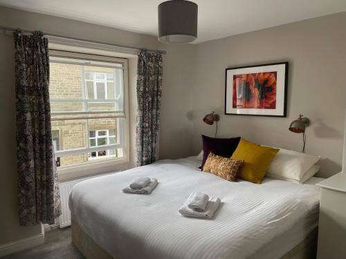 a bedroom with a large bed with towels on it at Bluebell Cottage in the Yorkshire Dales in Stainforth