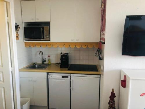 una pequeña cocina con fregadero y microondas en Appartement risoul 1850 residence pegase en Risoul