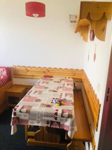 Cette chambre dispose d'une table et d'une couette. dans l'établissement Appartement risoul 1850 residence pegase, à Risoul