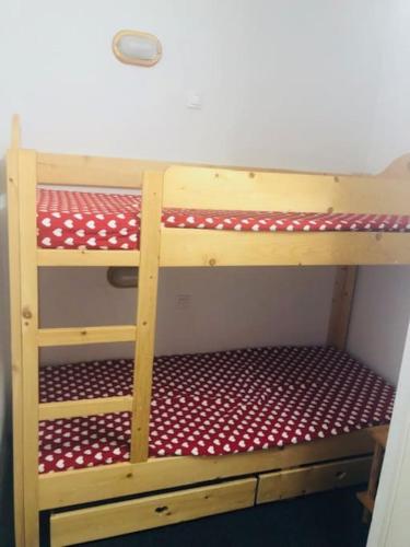 - un lit superposé en bois avec des points de polka rouges et blancs dans l'établissement Appartement risoul 1850 residence pegase, à Risoul