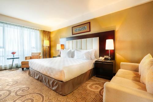 a hotel room with a bed and a couch at Best Western Premier Tuushin Hotel in Ulaanbaatar