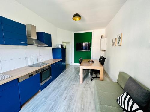 a kitchen with blue cabinets and a wooden table at FeWo Ischeland near Hagen-City in Hagen